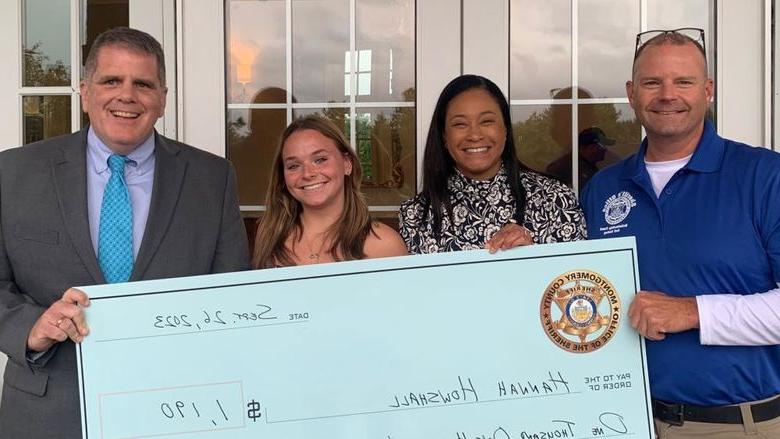 Montgomery County Sheriff's Office Chief Deputy Adam Berry, county Commissioner Jamila Winder, student Hannah Howshall, and Sheriff Sean Kilkenny with Hannah's scholarship check