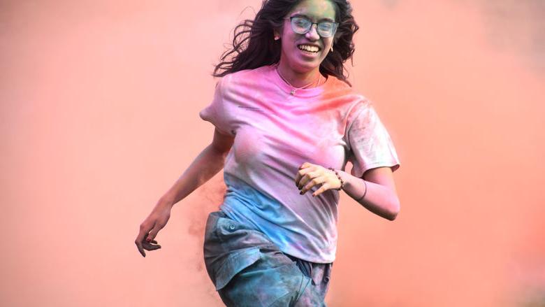 Penn State Abington student celebrates Holi by running through clouds of chalk